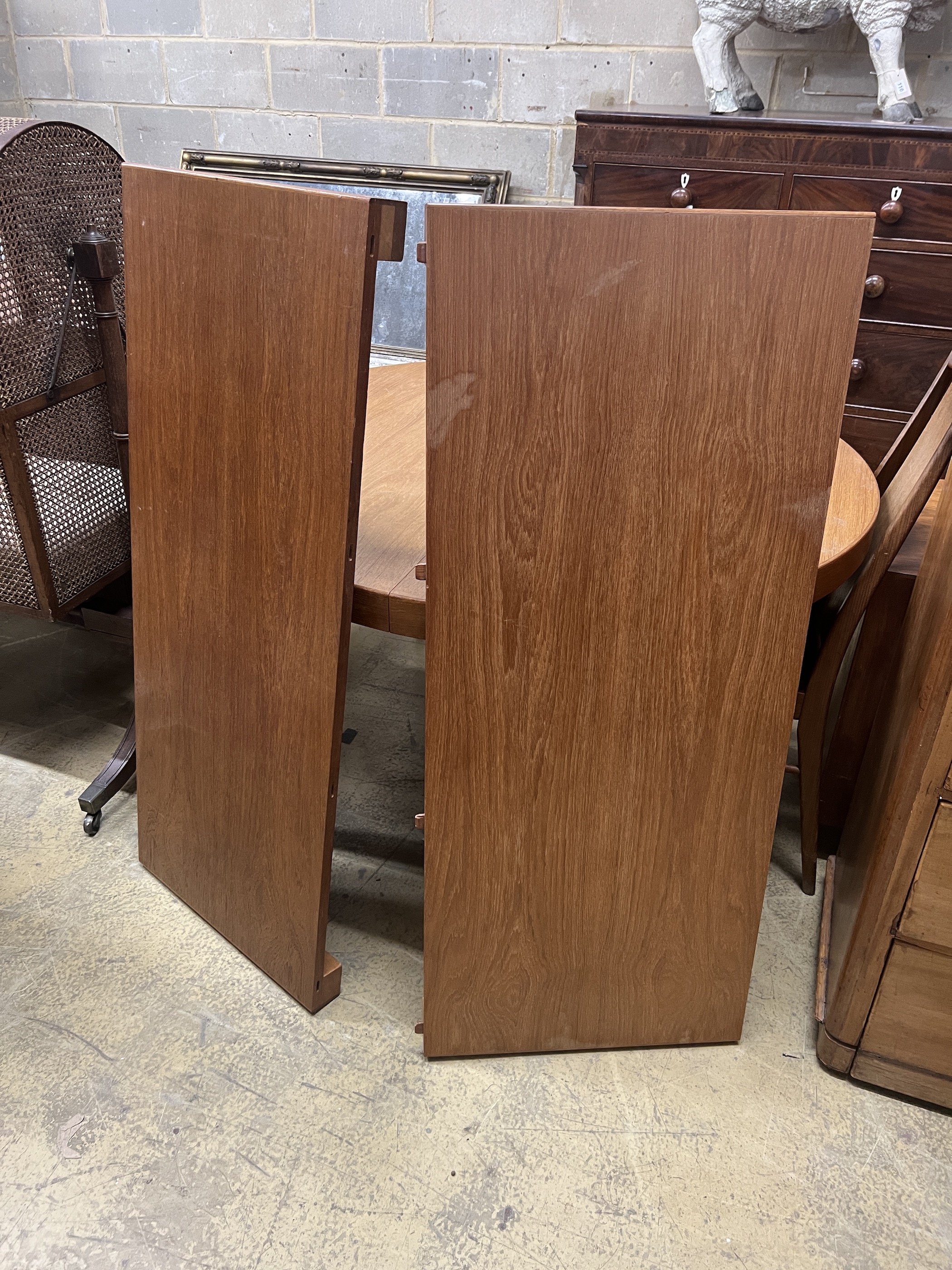 A mid century circular teak extending dining table, length 130cm extended, two spare leaves, depth 120cm, height 72cm